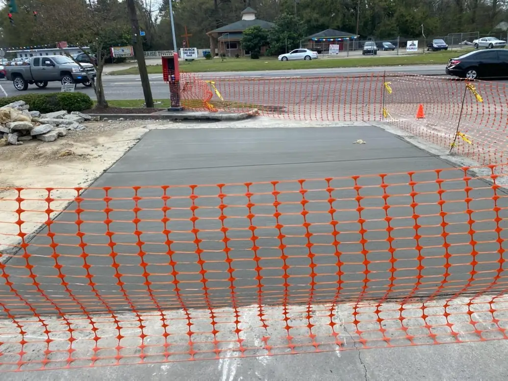 Fresh commercial concrete behind temporary safety fencing